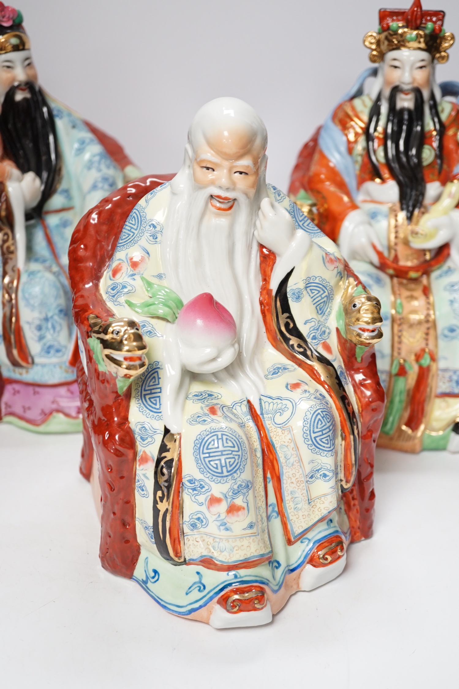 A set of three Chinese famille rose figures of the Three Star Gods (Sanxing), largest 25cm high